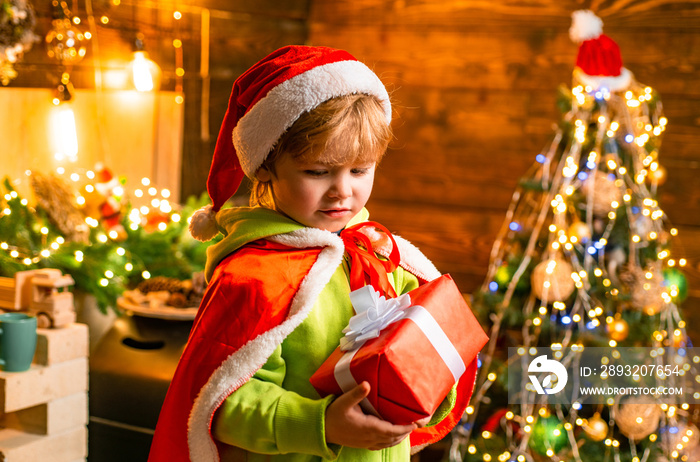 Cute little child boy play near christmas tree. Kid enjoy winter holiday at home. Home filled with j