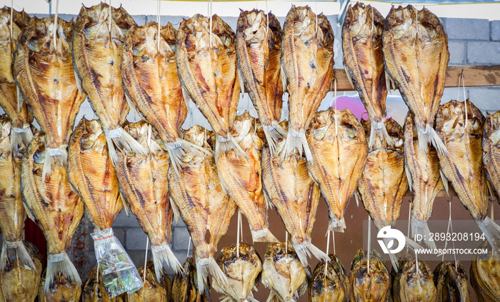 Dried fish hang on wooden drying rack