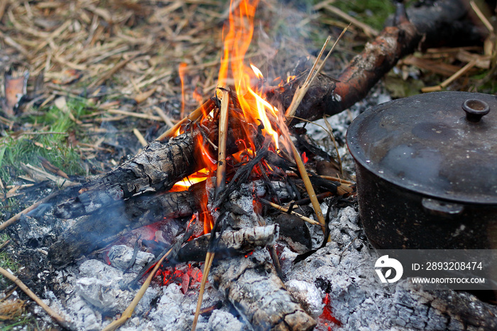 Сauldron on a bonfire. Outdoor touristic cooking concept on open fire. Old fashioned way to make foo