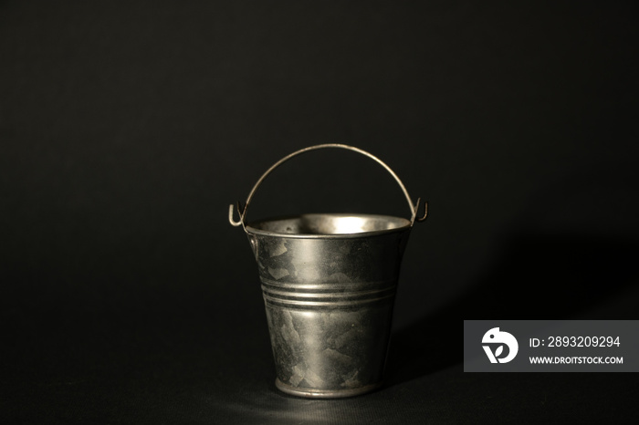 small stainless bucket on a dark background