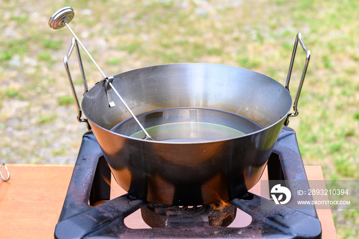 Pentola con olio per frittura e termometro per misurare la giusta temperatura dell’olio messa sul fo