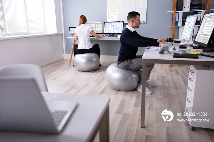 Businesspeople Working In Office Sitting On Fitness Ball