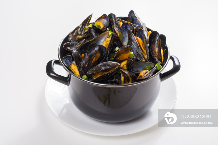 Black pan with cooked with green onion, parsley marinated high quality mussels