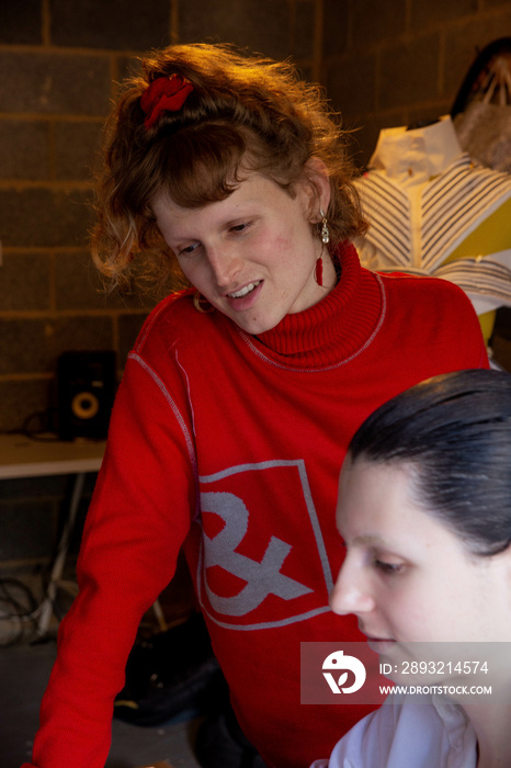 Two trans friends doing work together in their home studio.