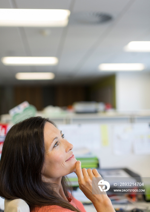 Happy businesswoman daydreaming in office