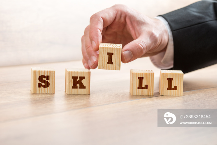 Businessman Arranging Blocks to Form Skill Word