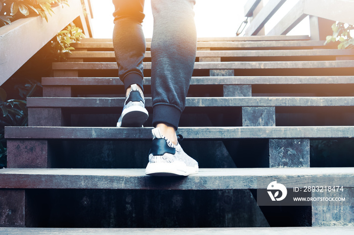 一个迈向成功的人，一个运动的人正在木台阶上攀登