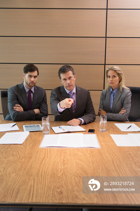 Serious businessman pointing in conference room meeting