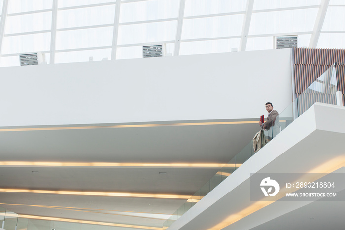 Businessman on modern office atrium balcony