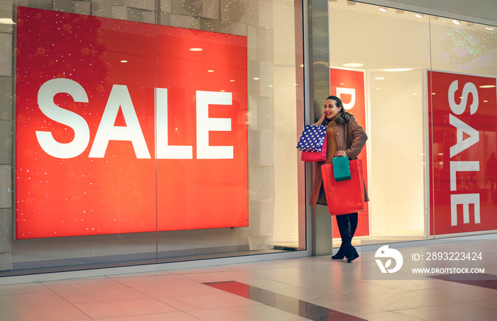 shopping and promotion concept- woman with shopping bags.