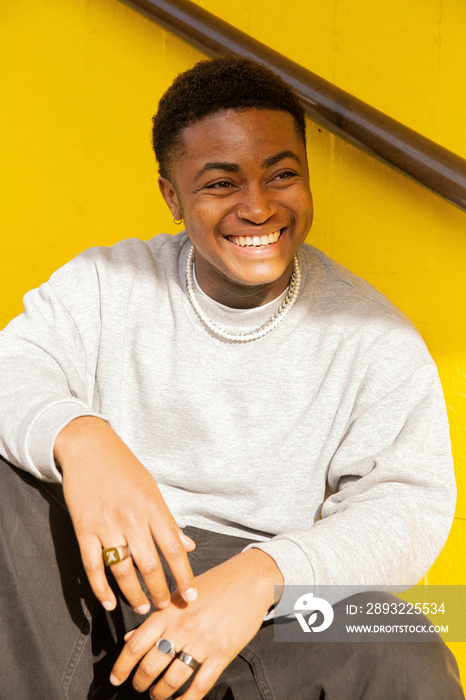 A portrait of a black trans masculine person smiling.