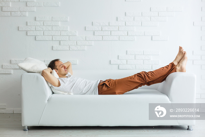 Calm handsome businessman sleeping on couch after work at home