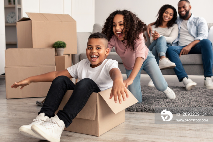 Happy black family celebrating moving day in new apartment