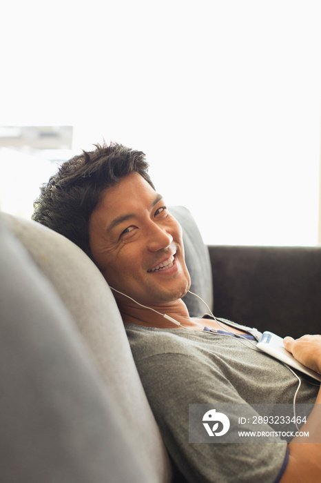 Portrait smiling man listening to music on sofa