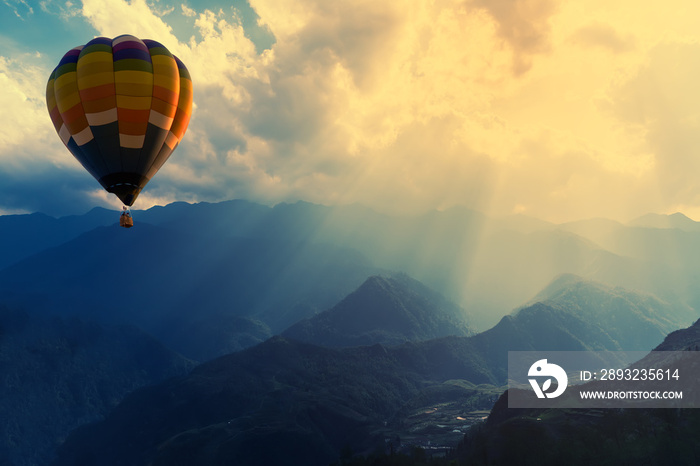 Colorful hot-air balloons flying over the mountain with sunbeam