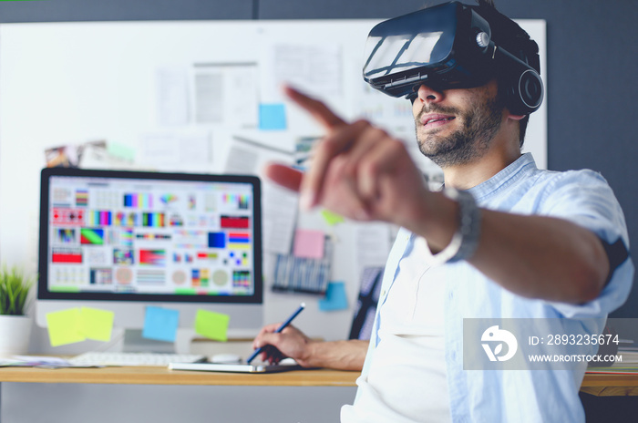 Young male software programmer testing a new app with 3d virtual reality glasses in office.