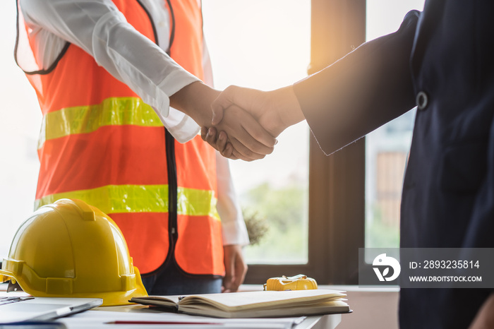 construction worker and contractor. Client shaking hands with team builder in renovation site.