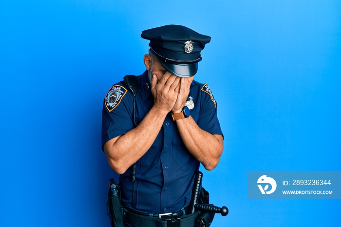 Middle age handsome man wearing police uniform with sad expression covering face with hands while cr