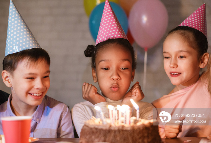 Girl blowing candles on birthday cake, celebrating birthday