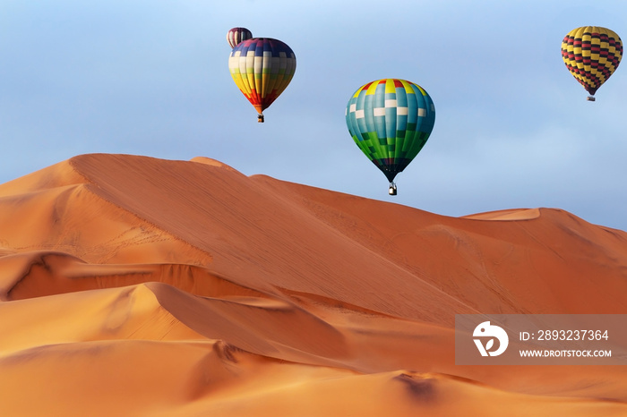 Beautiful Colorful Hot Air Balloons and dramatic clouds over the sand dunes in the Namib desert