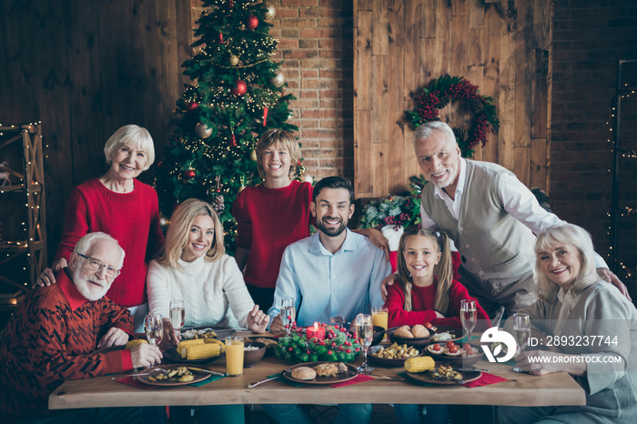 这是圣诞节。全家人聚在一起坐在餐桌上，几代人聚在一起摆姿势的照片。