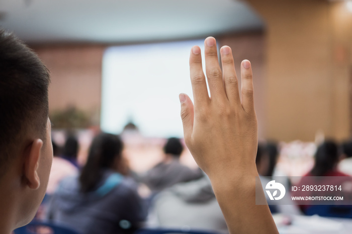 学生观众在会议舞台上发言时举手回答问题