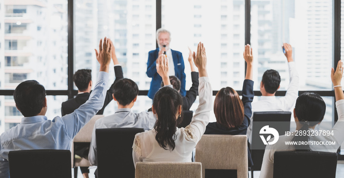 Group of business people raise hands up to ask question and answer to speaker in the meeting room se