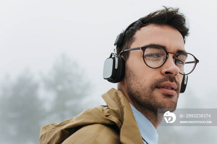 Horizontal close up portrait of handsome smart young Caucasian male wearing eyeglasses, looking at t