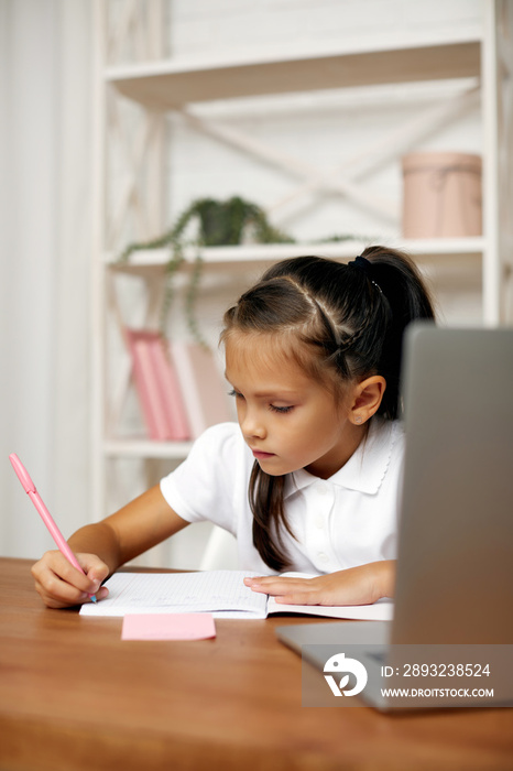 happy little child girl using laptop computer for studying online e-learning system. online educatio