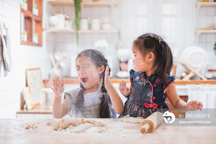 两个可爱的女孩在家厨房做蛋糕/做饭