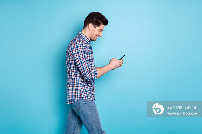 Photo portrait of careless positive optimistic handsome millennial holding using telephone while hav