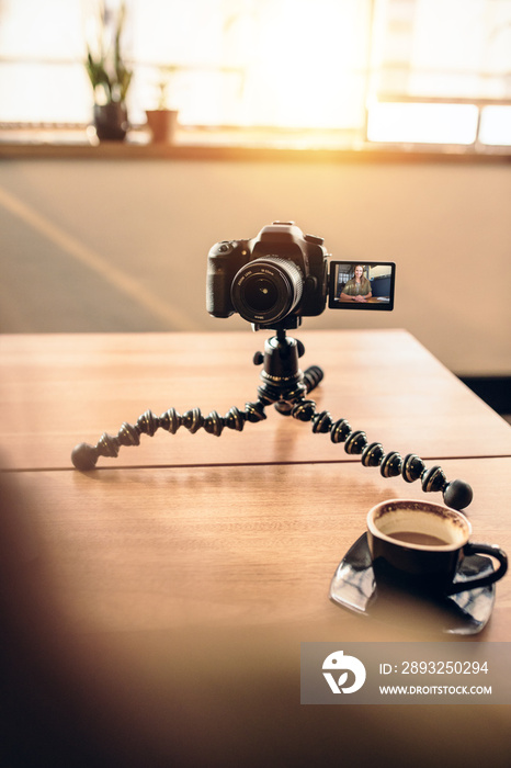 带咖啡和三脚架的数码相机的摄影师办公桌