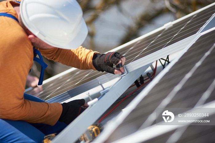 Male workers installing stand-alone solar photovoltaic panel system. Electricians mounting blue sola