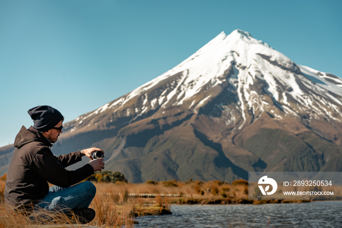 Young man poring water on argentinian drink called mate in Mount Taranaki, New Zealand