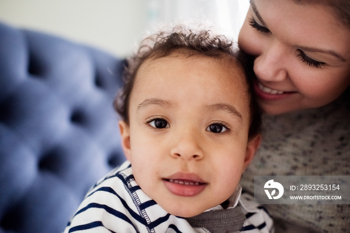 Close-up of smiling mother with cute son sitting at home