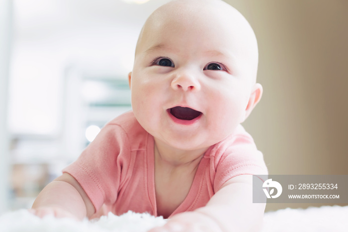 Happy newborn baby girl smiling