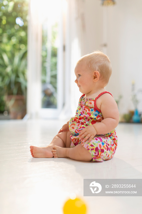 Cute baby girl sitting on floor