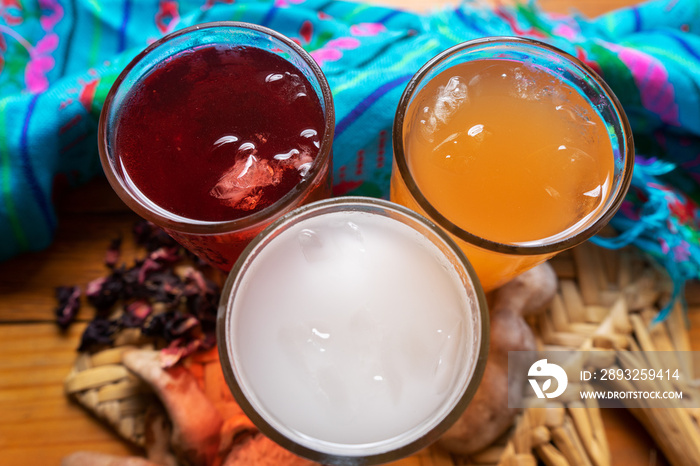 Set of mexican fresh water also called  aguas frescas . Hibiscus, tamarind and horchata on wooden ba