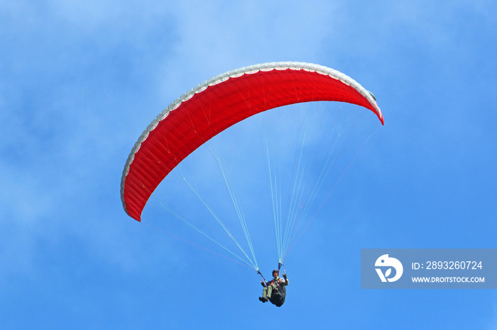 red paraglider in a blue sky