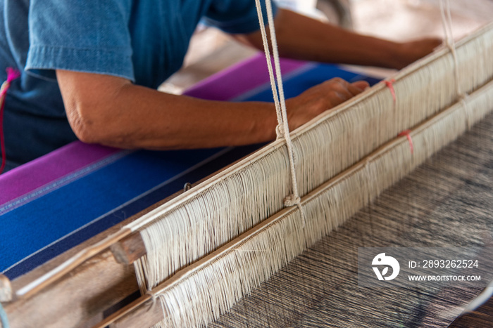 People are weaving with traditional Thai Lanna weaving machines