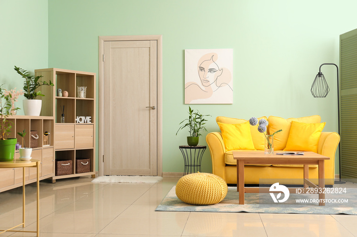 Interior of modern living room with stylish sofa and wooden shelving unit