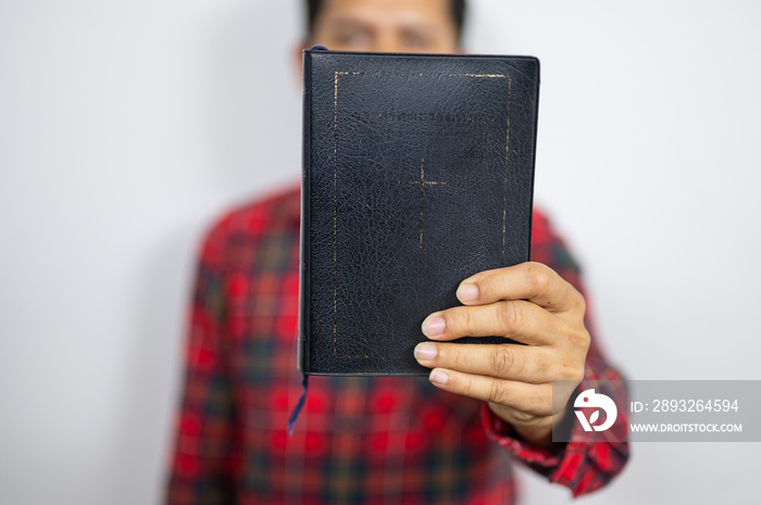 Believer man holding bible book on chest