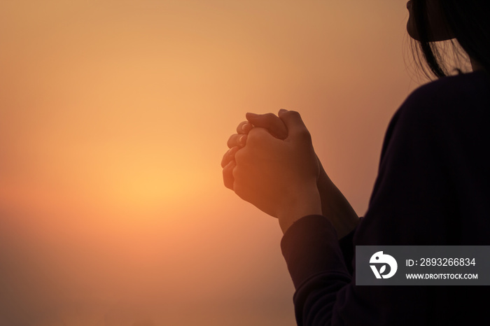 基督教妇女在日落时祈祷。双手合十祈祷。用基督教概念崇拜上帝