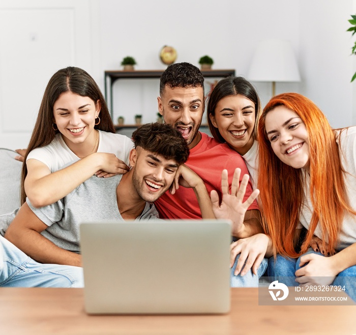 一群坐在家里沙发上用笔记本电脑进行视频通话的年轻朋友。