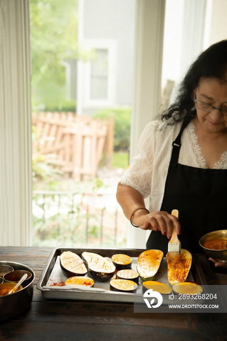 Woman brushing pesto on eggplant