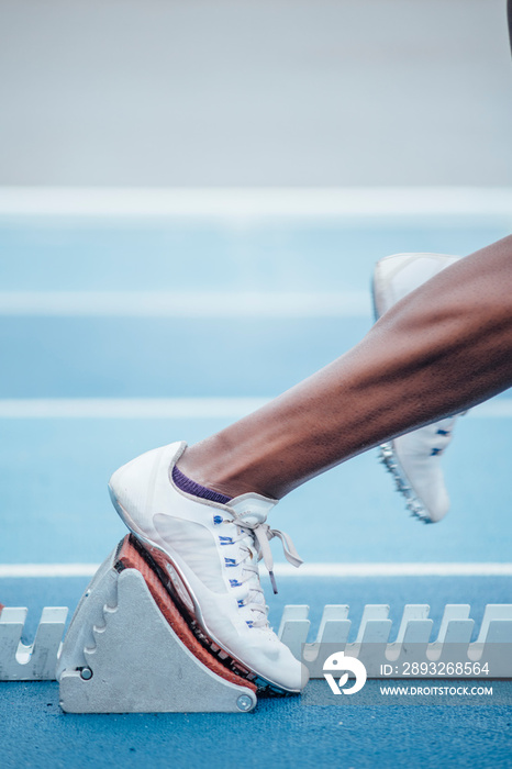 不可识别的身穿运动服的非洲裔女运动员从起跑时的蹲姿开始比赛
