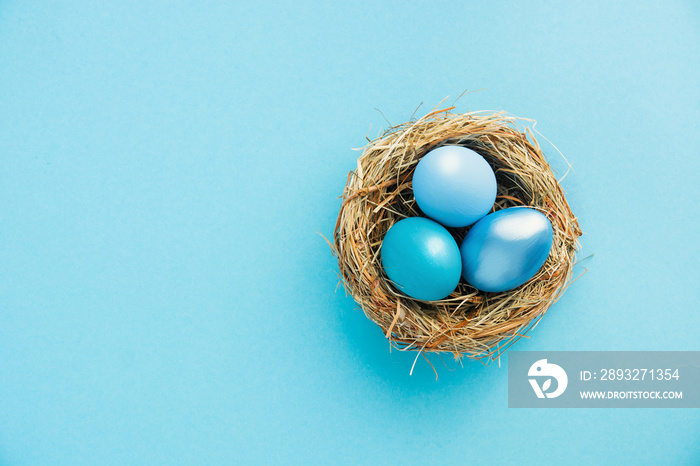 colored blue and azure Easter eggs in nest top view background, selective focus image. Happy Easter 