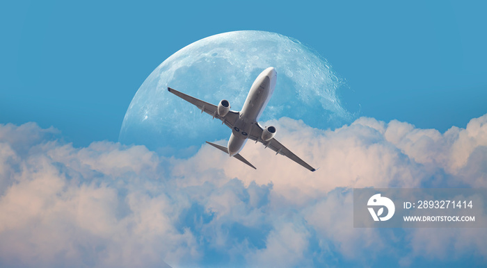 White passenger airplane rising over amazing clouds , full moon in the background  Elements of this 