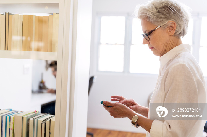 Side-view of senior woman texting