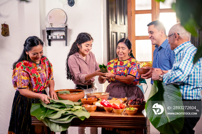 Familia cocinando Tamales, platillo tradicional Guatemalteco. La familia se divierte cocinando junto